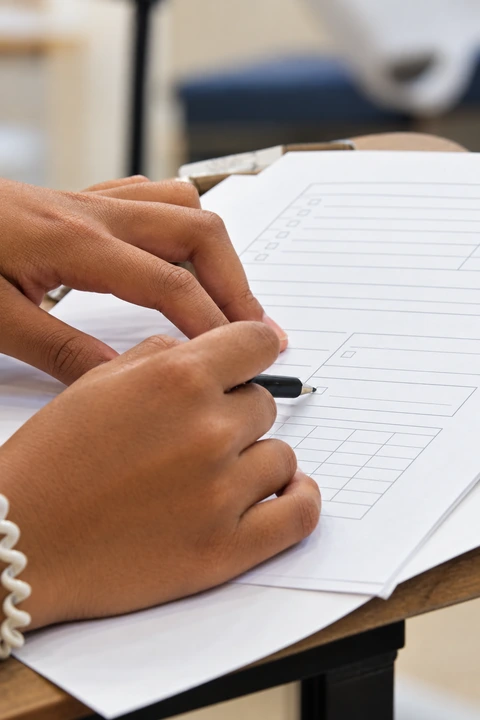 AI-enhanced color illustration of hands reviewing paperwork, based on the original website photo.